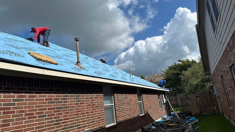 PL Roofing roofer laying underlayment on a brick home