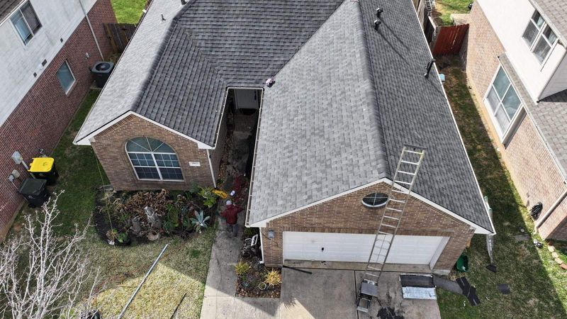 Aerial view of a brick home in Conroe, TX on a PL Roofing roof replacement job