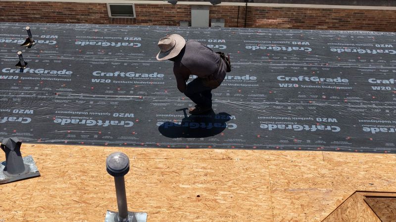 PL Roofing roofer fastening underlayment over new roof decking