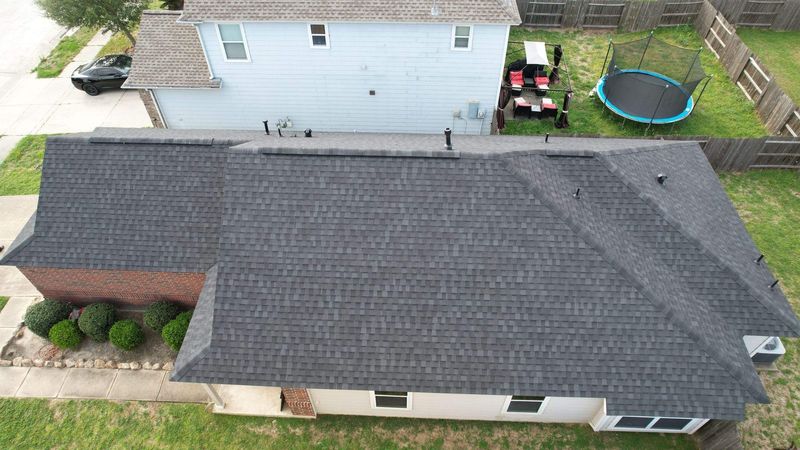 Aerial view of a new dark shingle roof on a home in Klein, TX