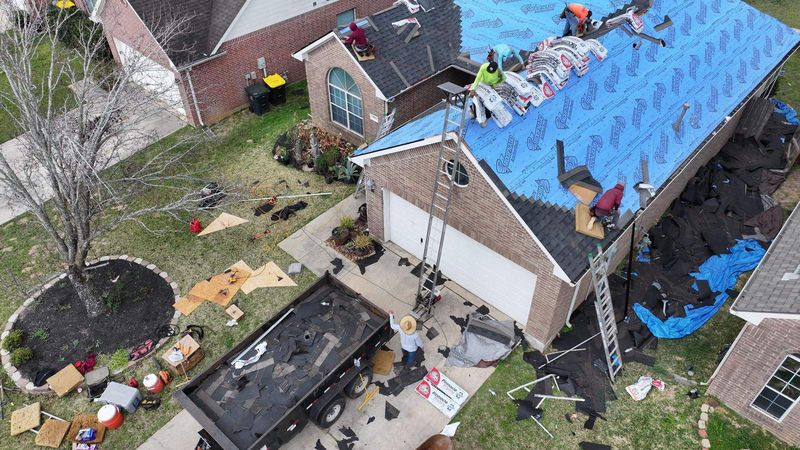 Aerial view of a PL Roofing crew replacing the roof on a brick home