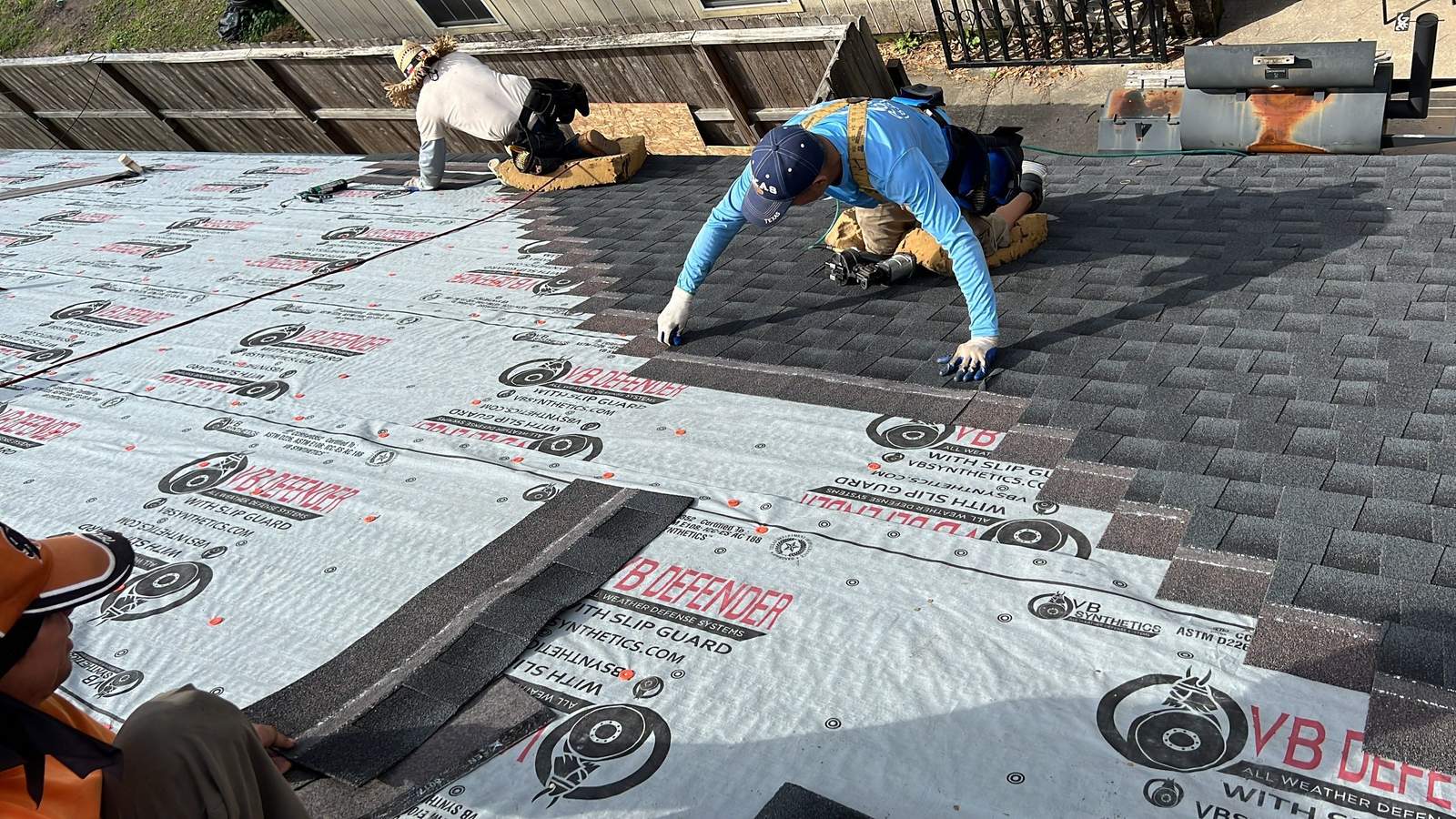 PL Roofing crew laying shingles over synthetic underlayment