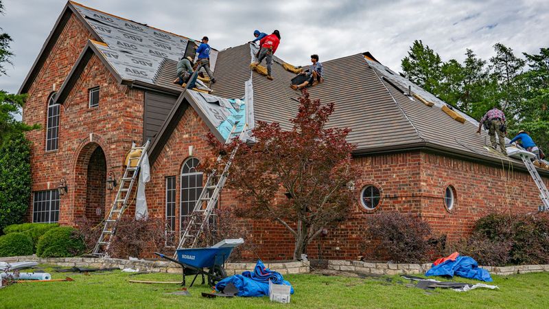 Equipo de techado renovando una gran casa de ladrillo de Texas con lonas protegiendo el jardín — Día de Instalación