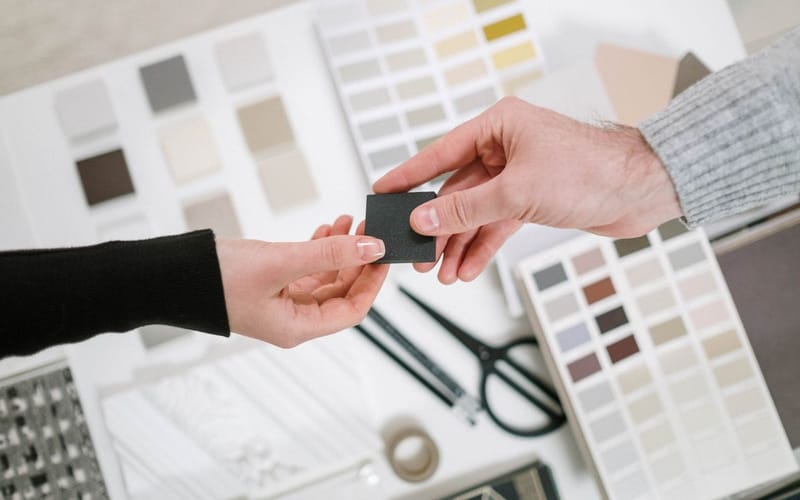 Homeowner and contractor choosing a roofing color and material sample